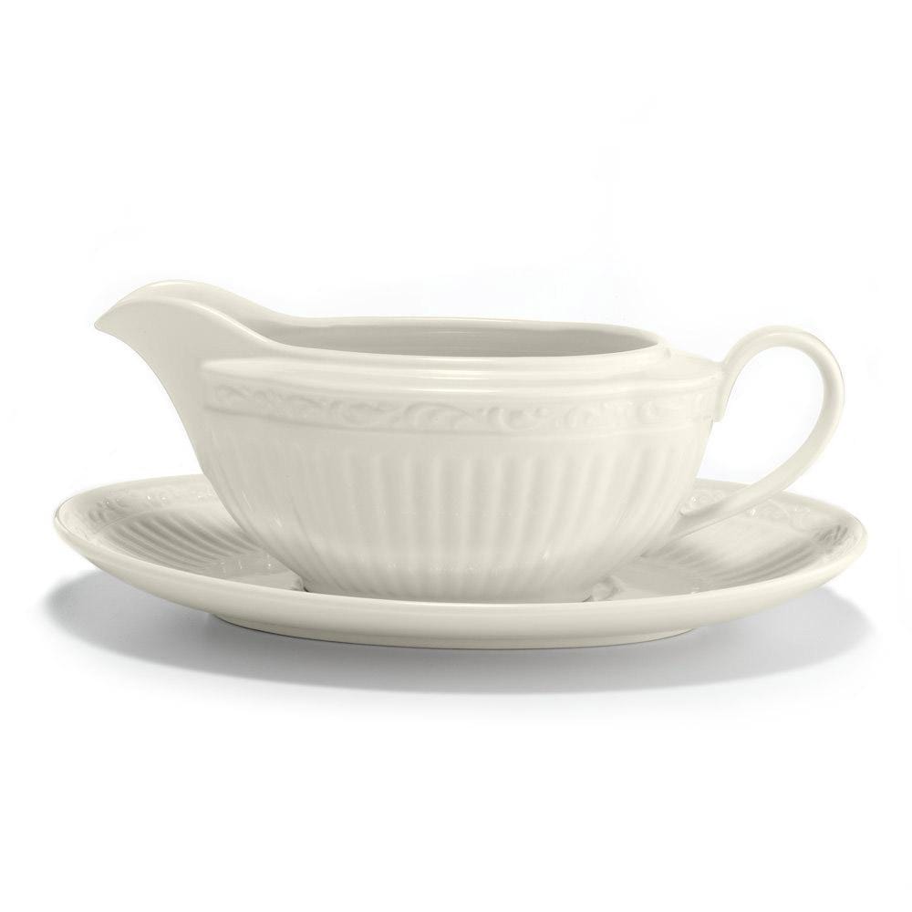 White ceramic gravy boat with matching saucer on a white background