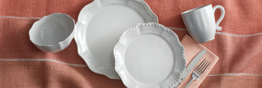Set a traditional table with Alyse Dinnerware. Beautifully crafted from high-quality stoneware, this traditional dinnerware features bold scalloped edges framed with an embossed bead pattern.