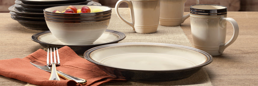 Bailey dinnerware, cream stoneware pieces are bordered by warm earth tones reminiscent of stained wood accents in a home, creating a look that is inviting and timeless.