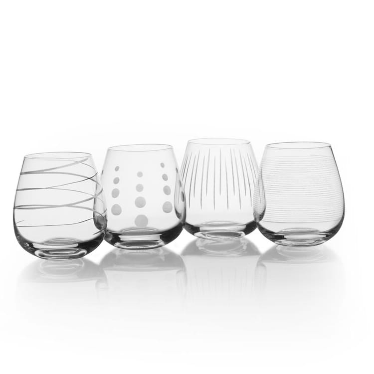 Four clear glass tumblers with different patterns on a white background
