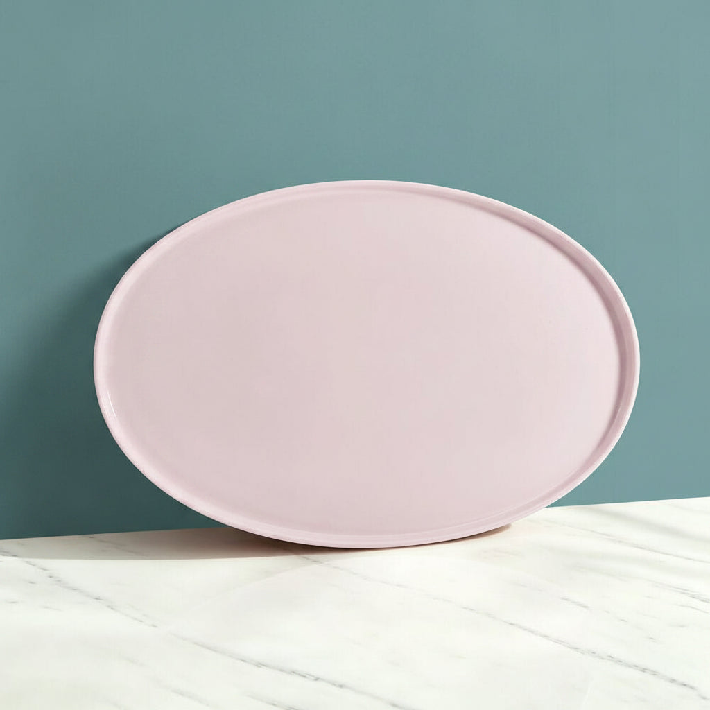 Pink oval tray on a light gray surface with a neutral background